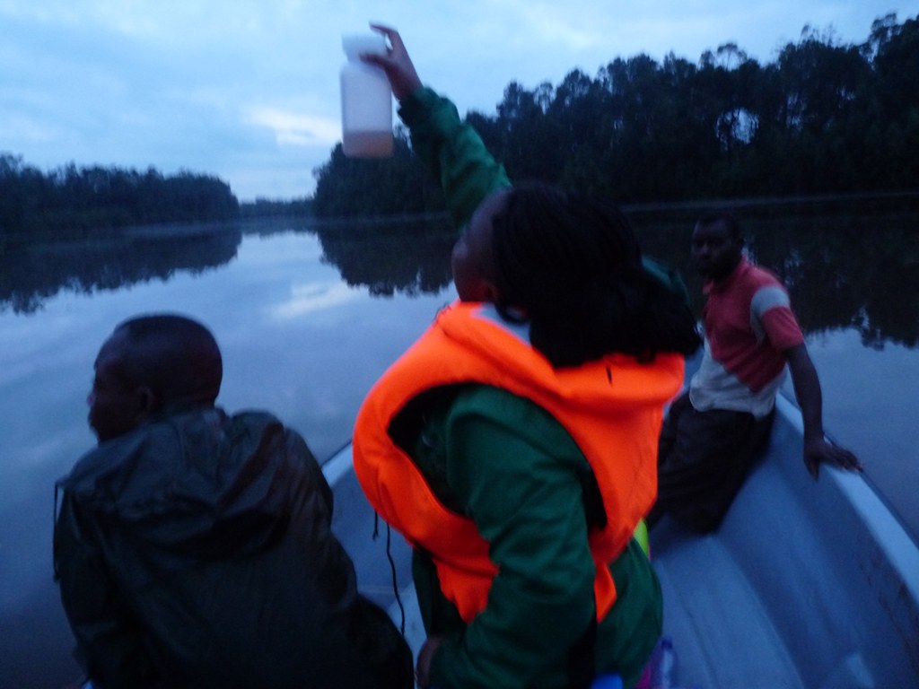 Researchers collecting a water sample from a boat in Muanda
