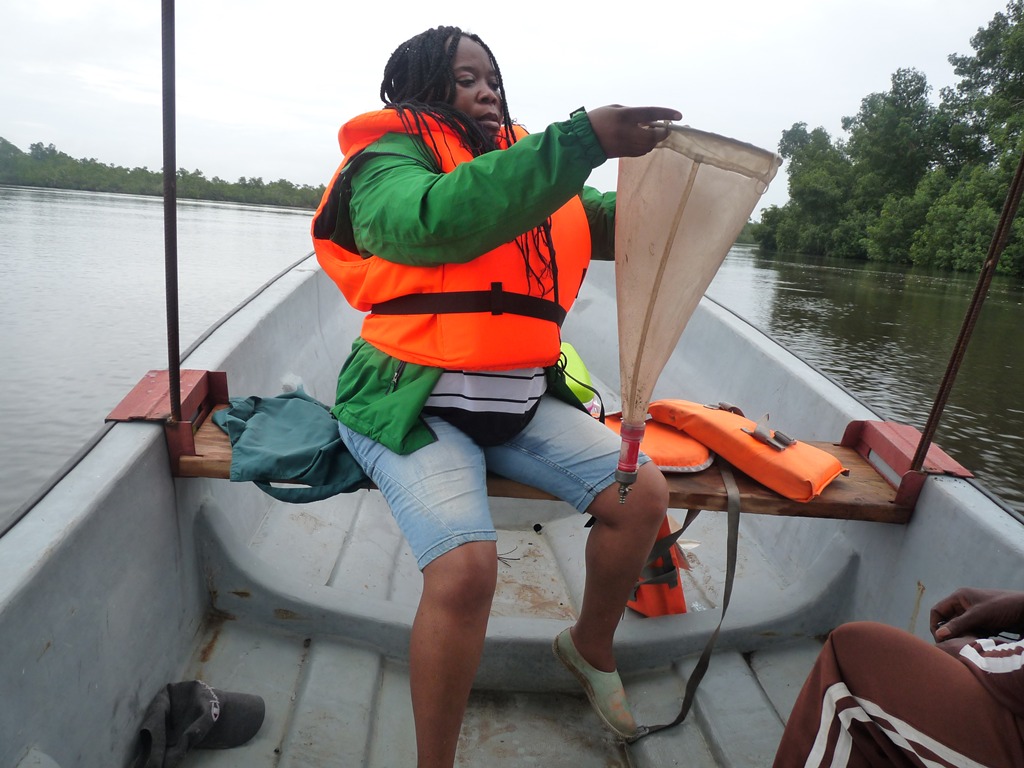 Researcher handling a plankton sampling net from a boat